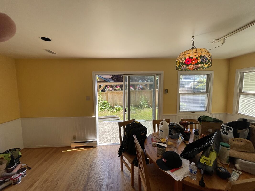 Before: a dining area with yellow walls, a stained-glass hanging lamp and a patio door.