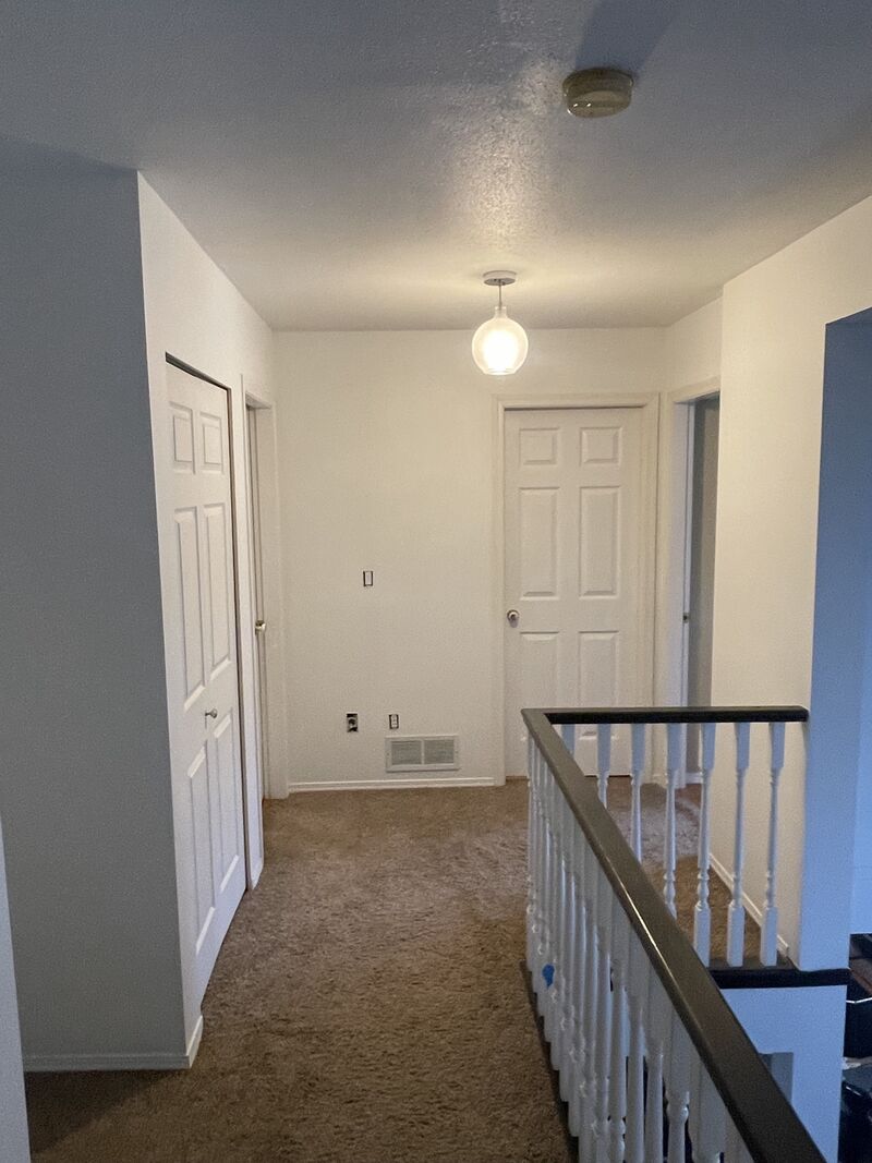 After: the same upstairs hallway with the walls repainted a light neutral.