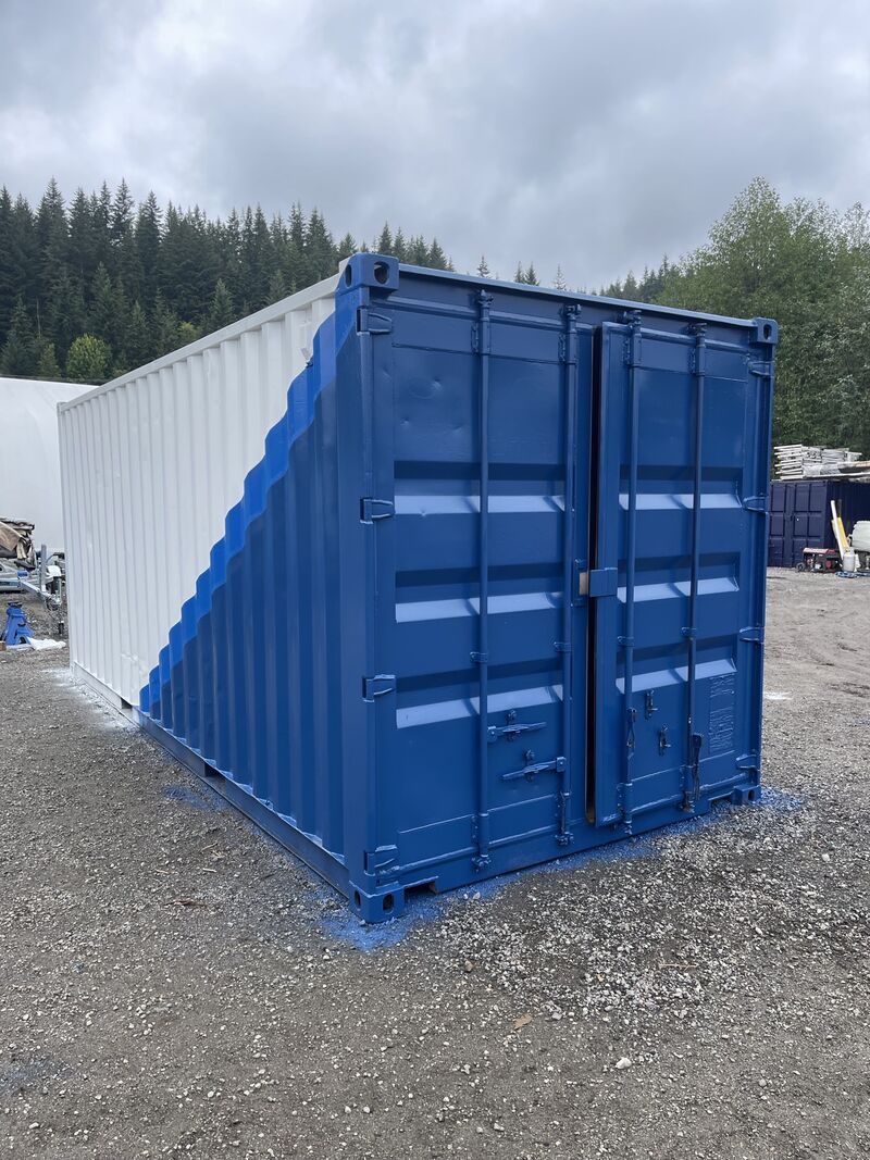 Door end of the second container painted deep blue, the white side running behind it.
