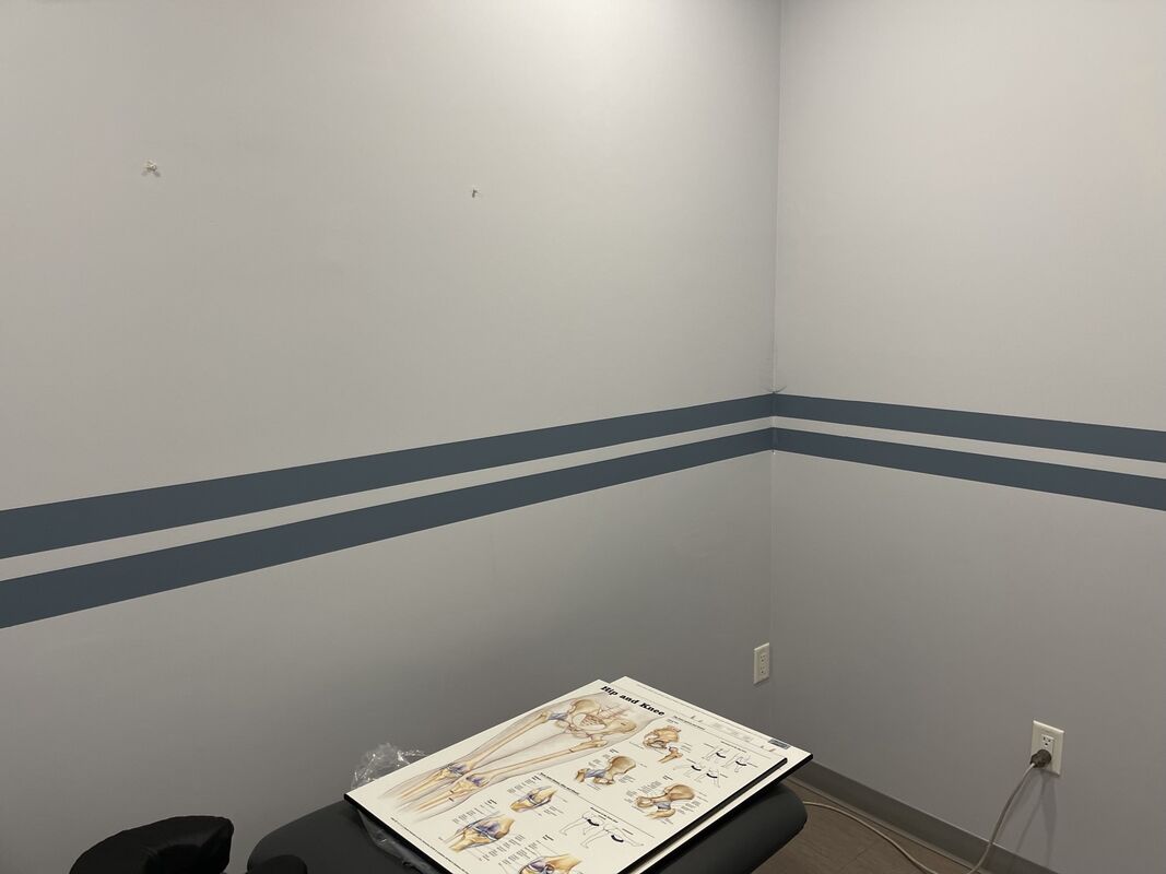 A treatment room with a two-band blue-grey stripe running around the walls.